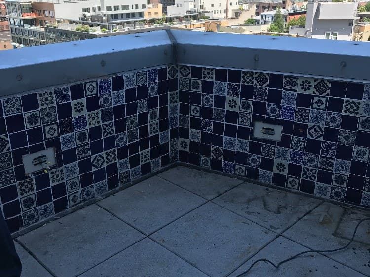 Rooftop terrace with old blue tile and exposed concrete before remodel