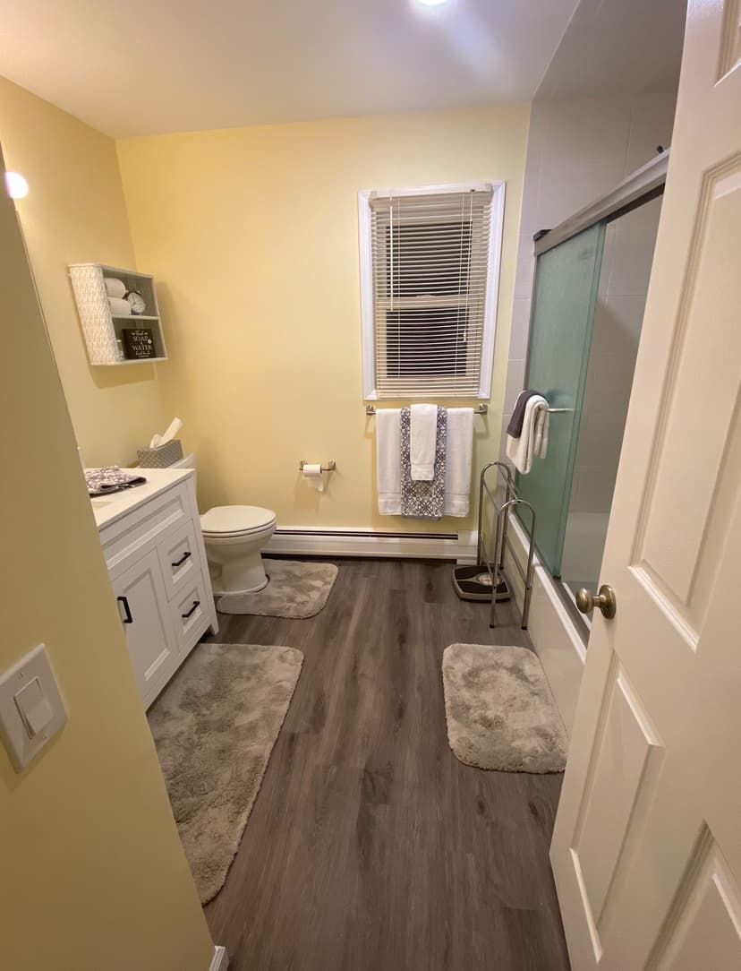 Updated bathroom with new white vanity, fresh paint, and wood-look flooring