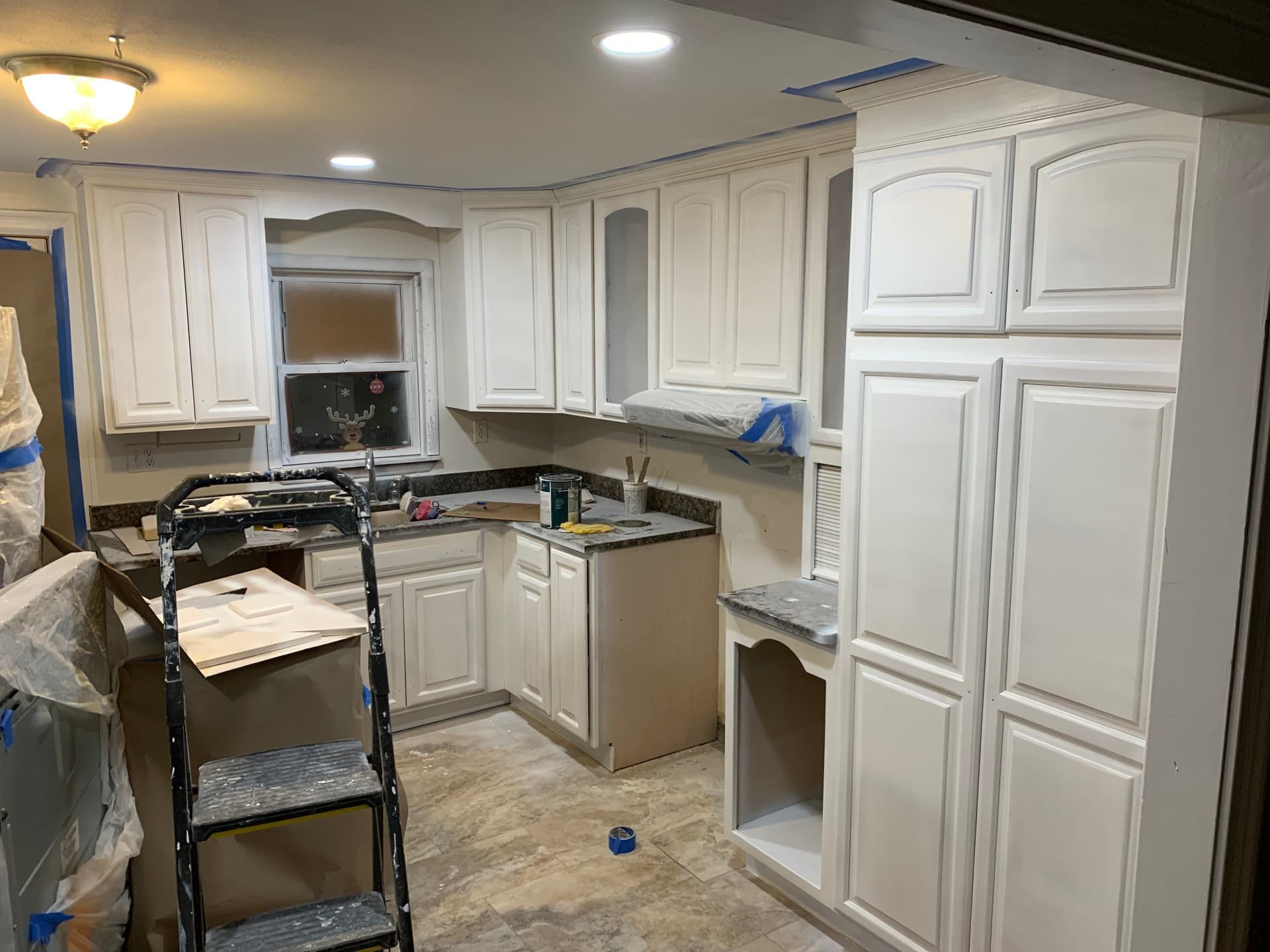 Freshly painted white cabinets after refinishing, ready for reinstall