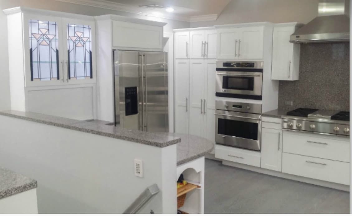 Bright white shaker-style cabinets after full refinishing and remodel
