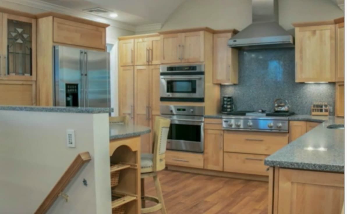 Dated honey maple kitchen cabinets with granite counters before refinishing