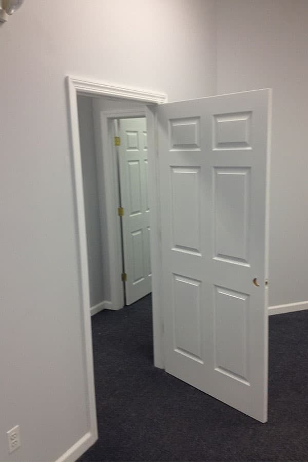 Freshly painted office with new six-panel doors and trim