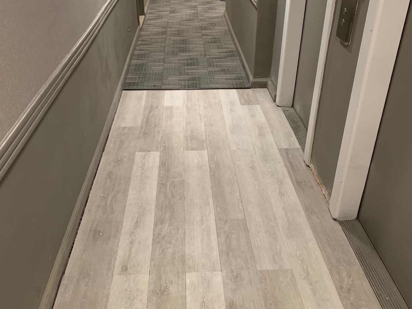 Renovated apartment corridor with new flooring, paint, and trim