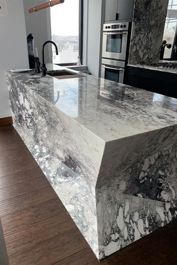 Mitered-edge Calacatta Viola marble island with waterfall sides