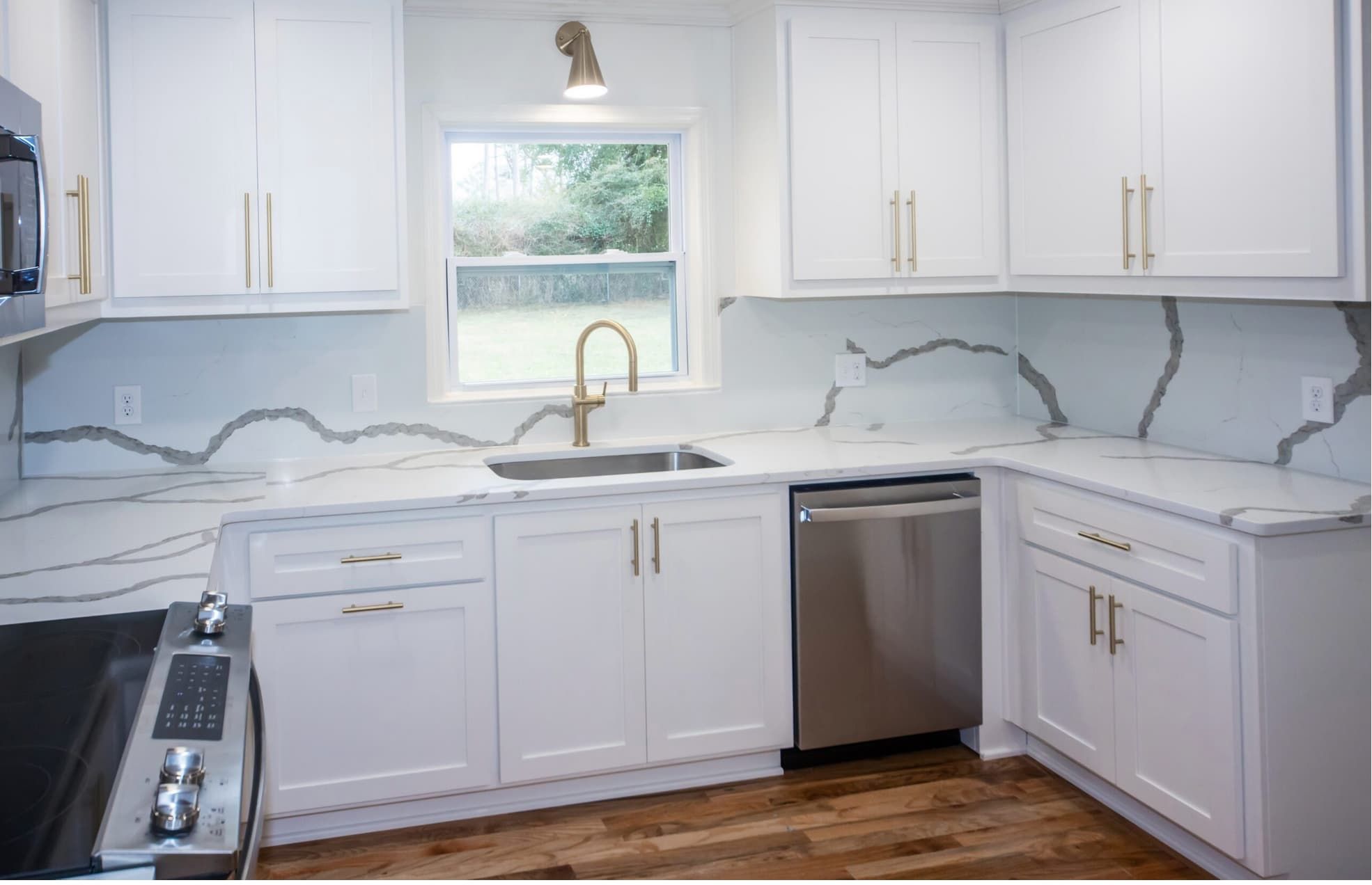 White shaker kitchen with Calacatta quartz countertops and matching backsplash