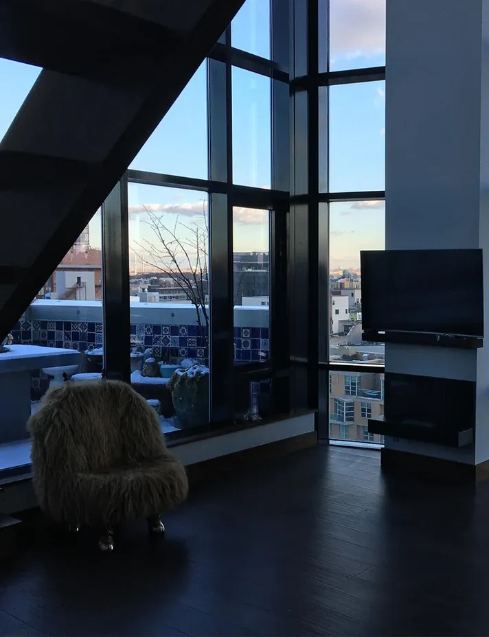 Floor-to-ceiling windows with dark hardwood floors