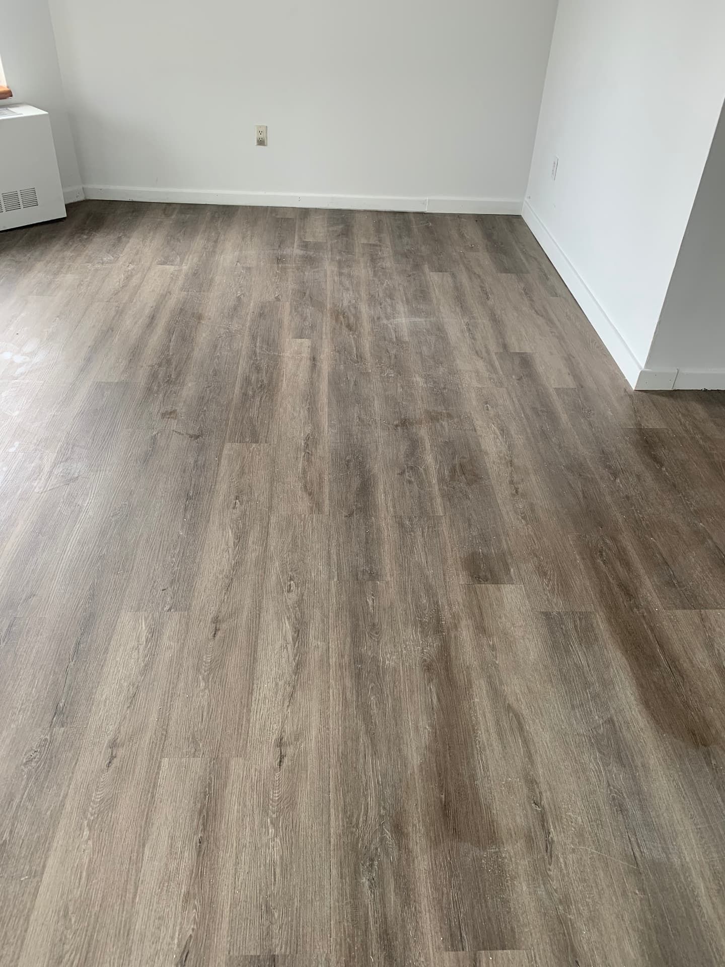 Warm gray luxury vinyl plank flooring in bright living room
