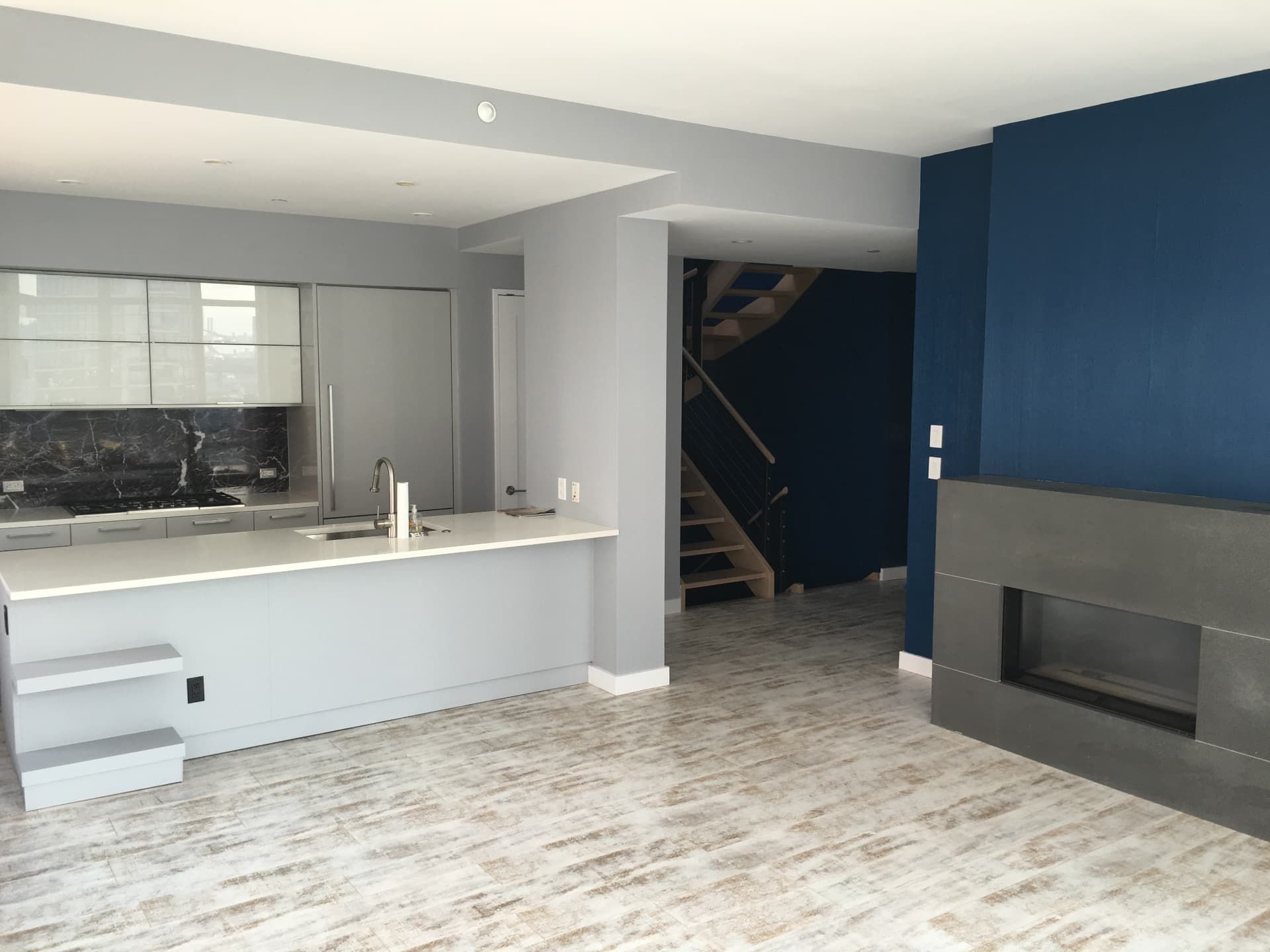 Open living space after new flooring, paint, and fireplace finishes