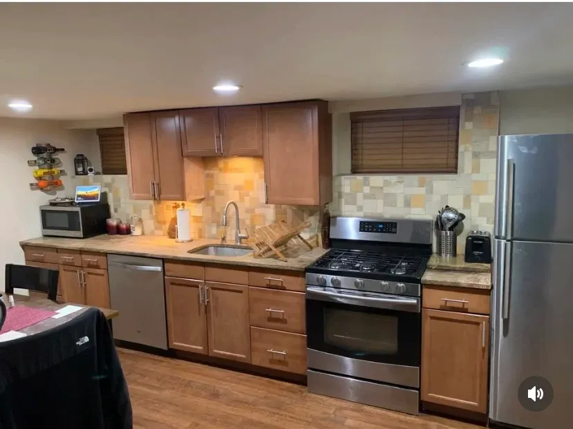 Basement kitchen with oak cabinets and stone backsplash before remodel
