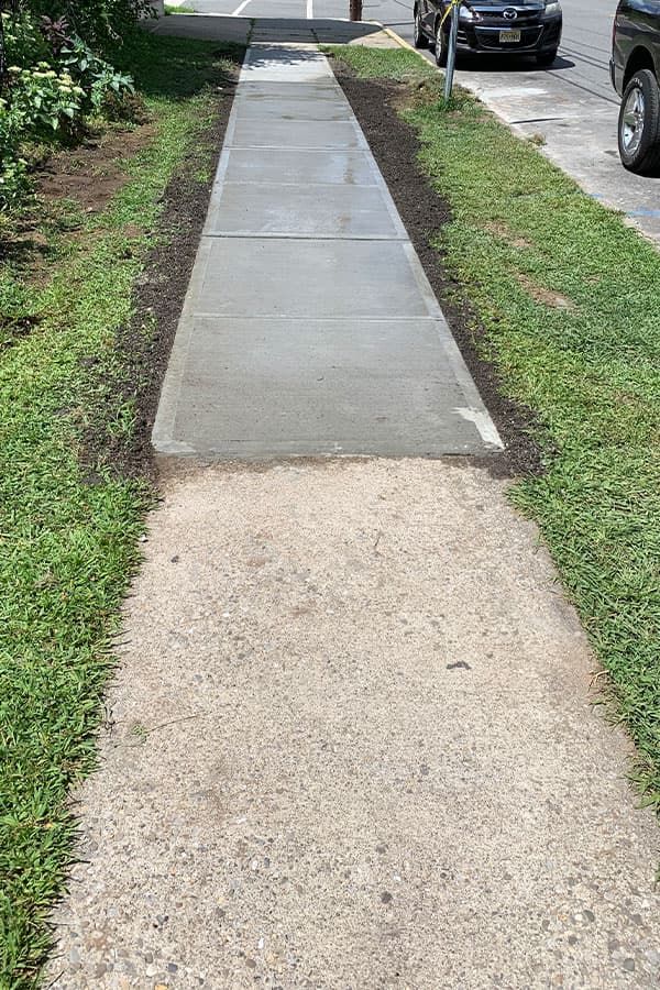 Newly poured concrete sidewalk next to old worn surface