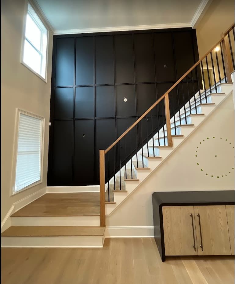 Dramatic black paneled accent wall along staircase