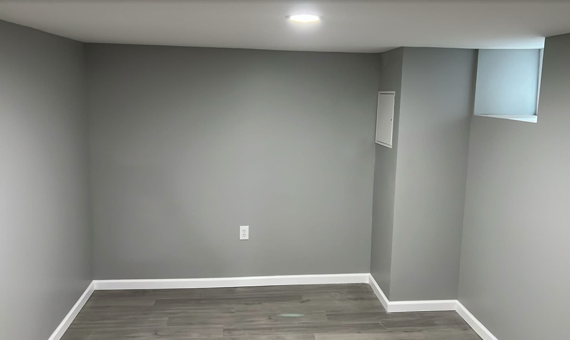 Smooth gray painted basement walls with crisp white trim